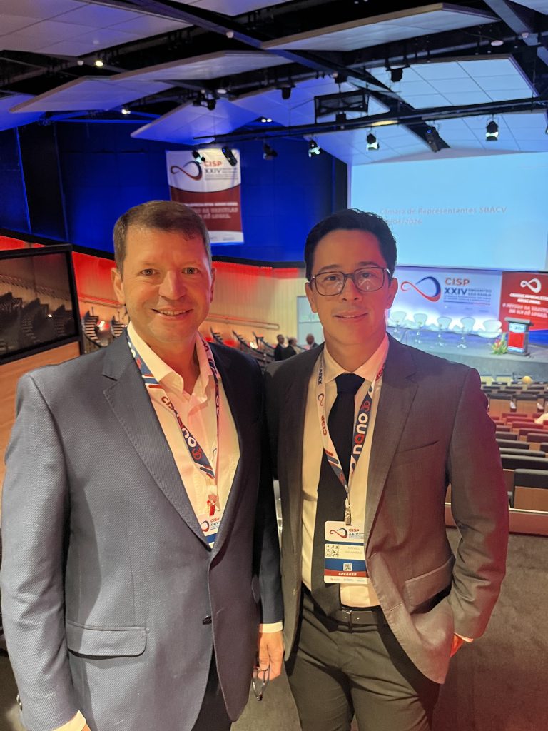 Dr. Daniel Drummond com colega no auditório do CISP 2026, no Centro de Convenções Rebouças, em São Paulo
