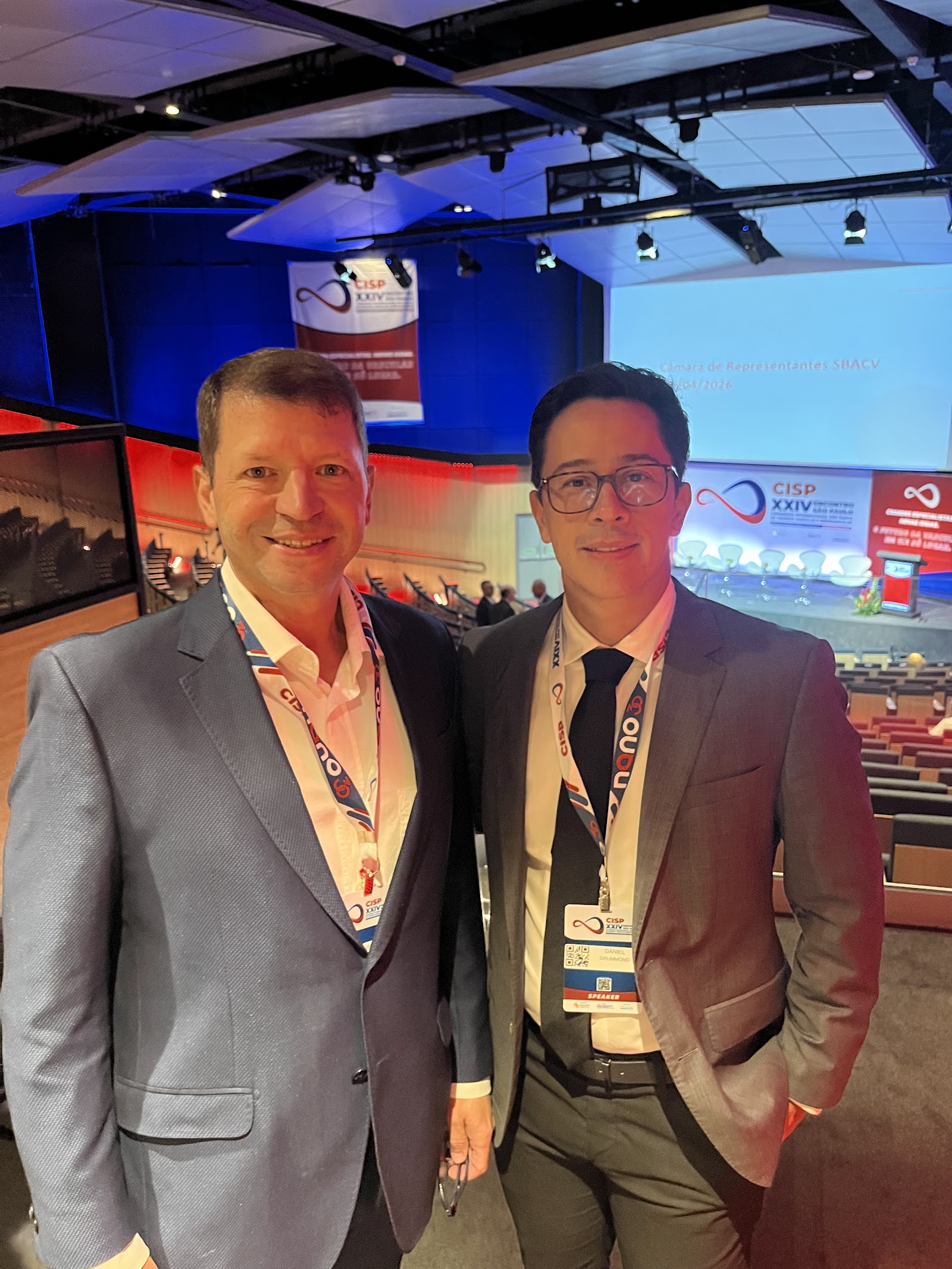 Dr. Daniel Drummond com colega no auditório do CISP 2026, no Centro de Convenções Rebouças, em São Paulo